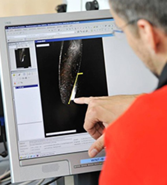 Employee Using a Coordinate Measuring Machine to Measure the Geometry of Part Employee Using a Coordinate Measuring Machine to Measure the Geometry of Part